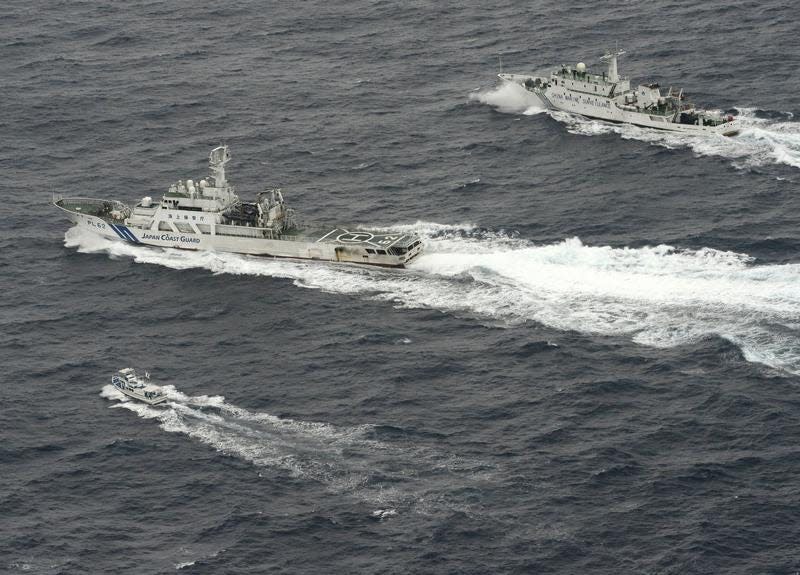 An aerial photo shows Chinese marine surveillance ship Haijian No. 66 (top) trying to approach a Japanese fishing boat (bottom) as Japan Coast Guard vessel Ishigaki cruises next to the Chinese ship, in the East China Sea, near what are known as the Senkaku isles in Japan and the Diaoyu islands in China, in this photo taken by Kyodo April 23, 2013. REUTERS/Kyodo