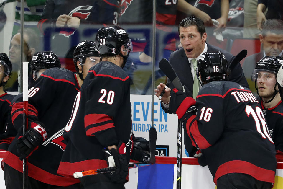 Carolina Hurricanes head coach Rod Brind'Amour talks with Carolina Hurricanes' Sebastian Aho (20), Teuvo Teravainen (86) and Vincent Trocheck (16) during a timeout in the second period of Game 2 of an NHL hockey Stanley Cup second-round playoff series against the New York Rangers in Raleigh, N.C., Friday, May 20, 2022. (AP Photo/Karl B DeBlaker)