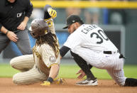 San Diego Padres' Fernando Tatis Jr., front left, slides safely into second base with a double as Colorado Rockies second baseman Harold Castro, right, applies a late tag in the fourth inning of a baseball game Friday, June 9, 2023, in Denver. (AP Photo/David Zalubowski)