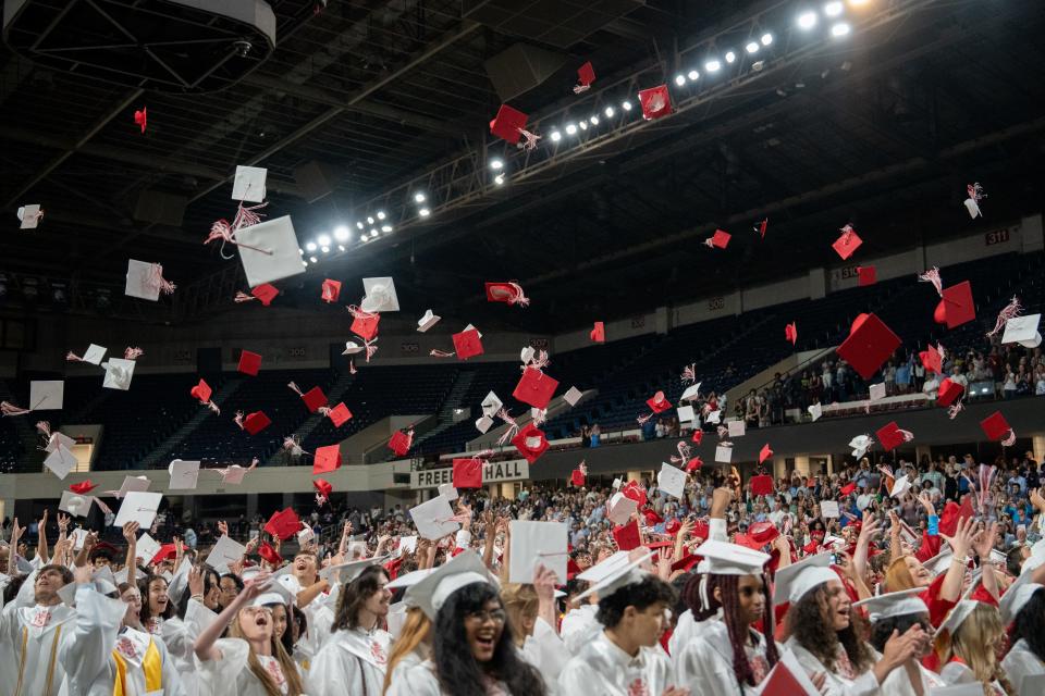 DuPont Manual High School graduates throw their caps in the air during their graduation ceremony on Saturday, May 25, 2024.