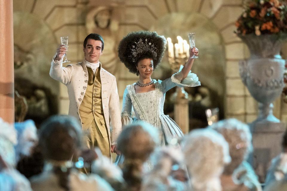 the queen and king raising their glasses for a toast