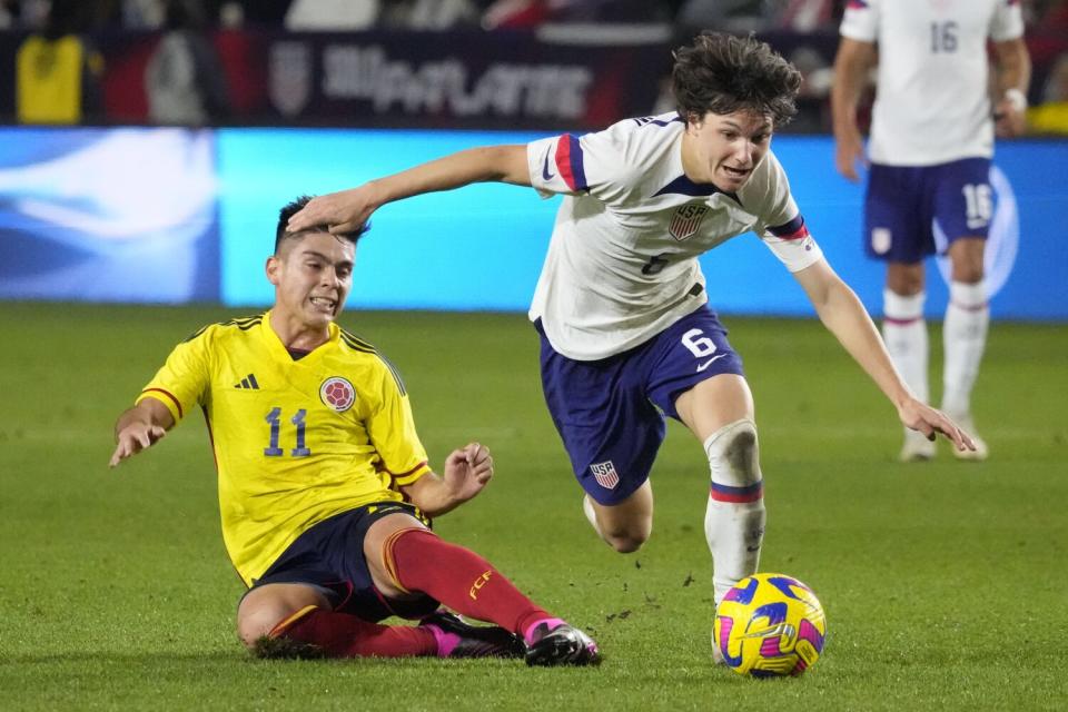 The United States' Paxten Aaronson, right, dribbles past Colombia's Daniel Ruiz during the second half Jan. 28, 2023.
