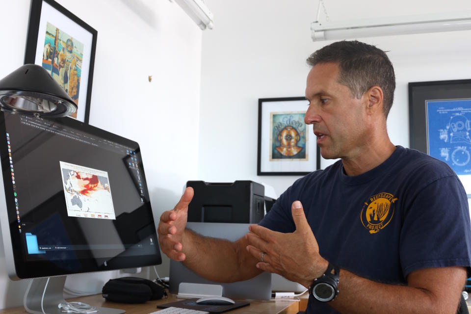 In this Sept. 13, 2019 photo, ecologist Greg Asner, the director of Arizona State University's Center for Global Discovery and Conservation Science, reviews ocean temperature data at his lab on the west coast of the Big Island near Captain Cook, Hawaii. "Nearly every species that we monitor has at least some bleaching," said Asner after a dive in Papa Bay. (AP Photo/Caleb Jones)
