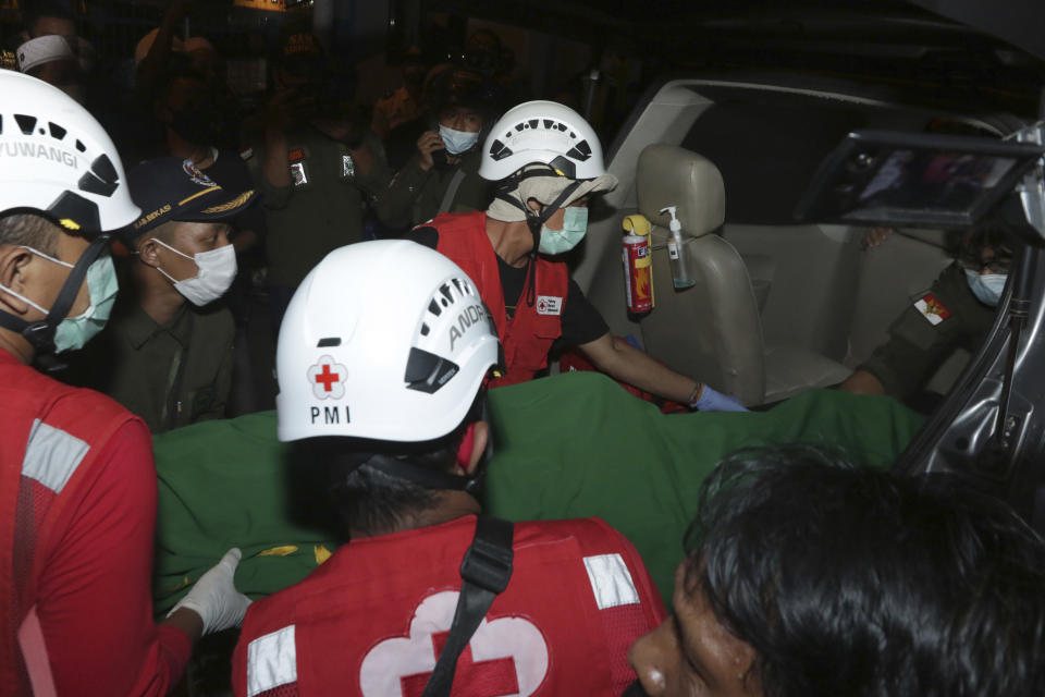 Rescuers carry the body of a victim of the sinking ferry KMP Yunice on a stretcher into a car in Banyuwangi, East Java, Indonesia, early Wednesday, June 30, 2021. Rescuers searched into the night Tuesday for several missing people after the ferry sank in rough seas near Indonesia's resort island of Bali, killing a number of people, officials said. (AP Photo)