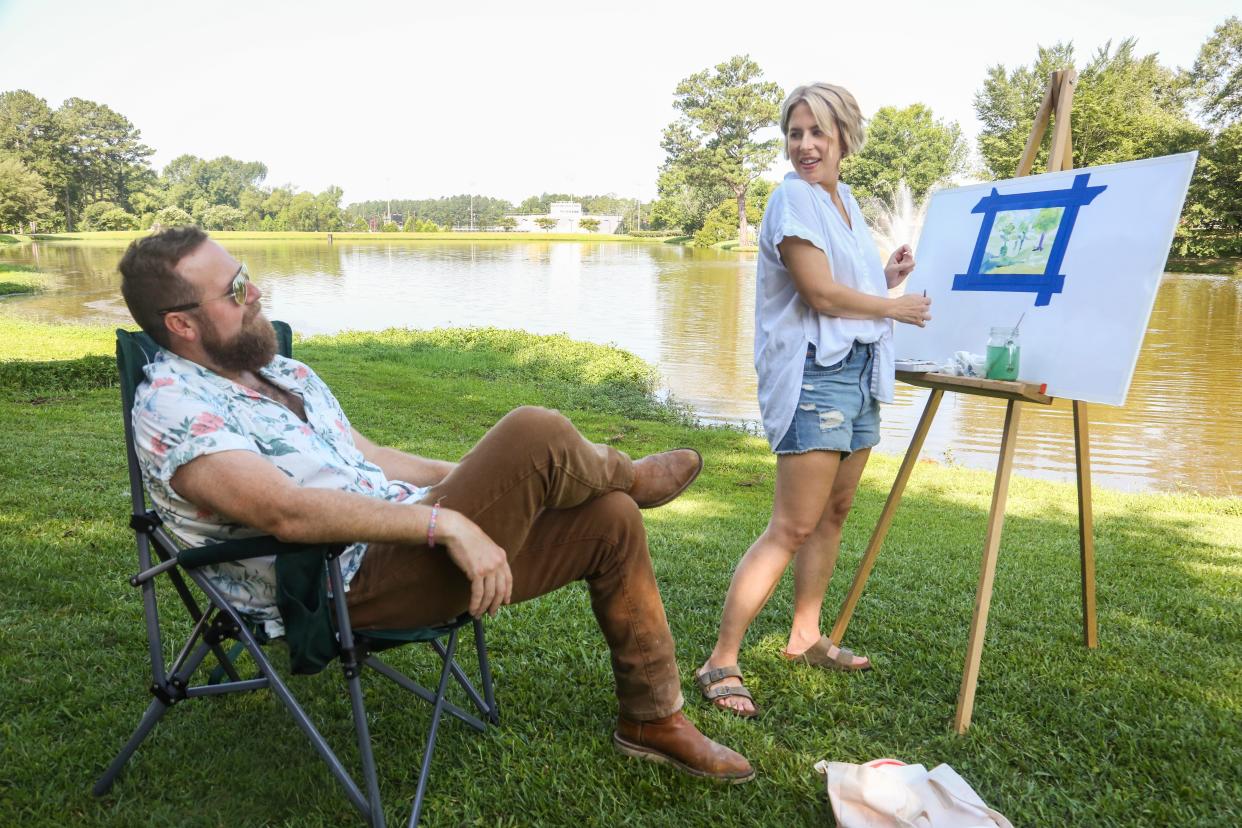 Erin Napier shows a painting to her husband and "Home Town" co-host Ben Napier.