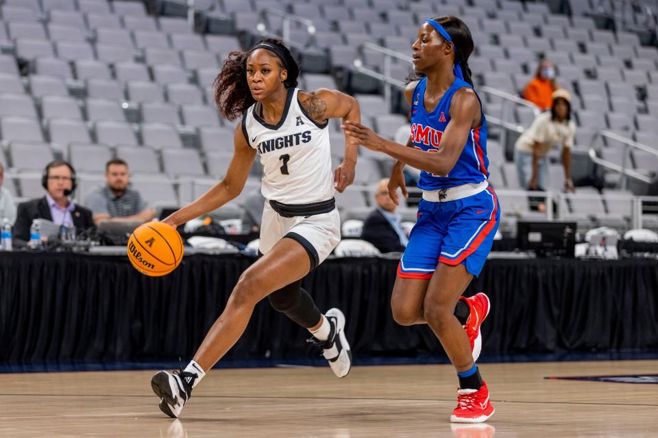 UCF guard Tay Sanders, left, drives the court against SMU guard Kayla White, right, in the first half of an NCAA college basketball semifinal round game at the women's American Athletic Conference tournament in Fort Worth, Texas, Wednesday, March 9, 2022. (AP Photo/Gareth Patterson)