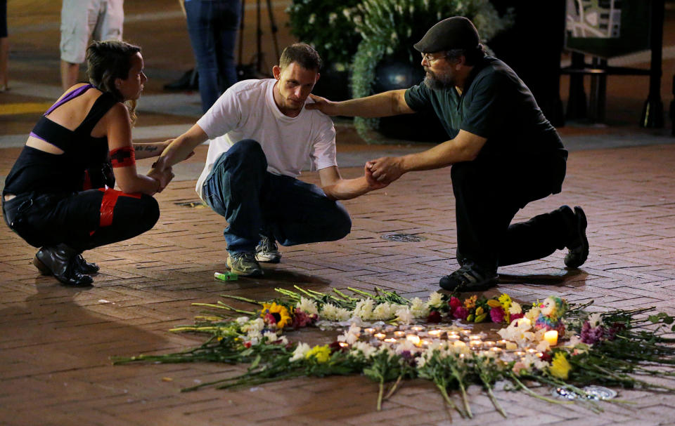 <p>Two people stop to comfort Joseph Culver (C) of Charlottesville as he kneels at a late night vigil to pay his respect for a friend injured in a car attack on counter protesters after the “Unite the Right” rally organized by white nationalists in Charlottesville, Virginia, U.S., August 12, 2017. Picture taken August 12, 2017. (Jim Bourg/Reuters) </p>