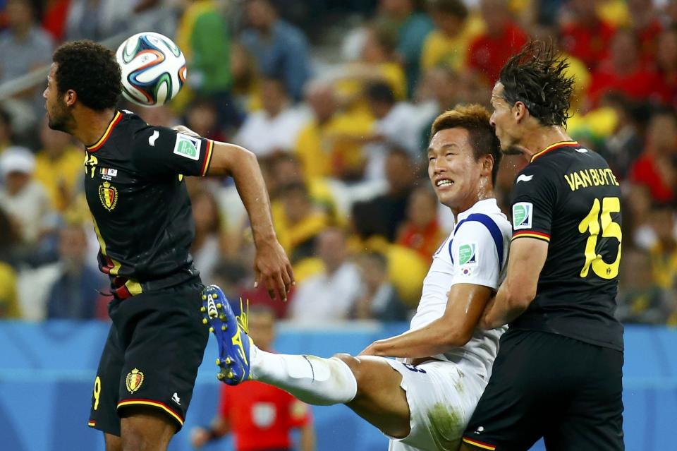 South Korea's Kim Shin-wook fights for the ball with Belgium's Moussa Dembele and Daniel Van Buyten during their 2014 World Cup Group H soccer match in Sao Paulo