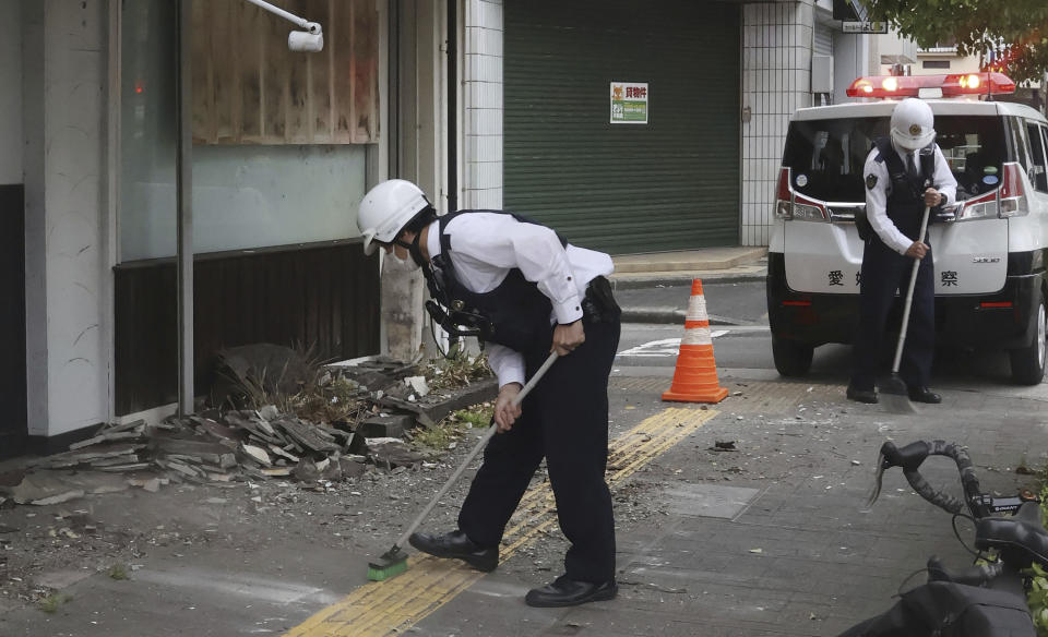 Police officers clean the debris from an earthquake in Uwajima, Ehime prefecture, western Japan Thursday, April 18, 2024. According to Kyodo News reports, a strong earthquake hit Ehime and Kochi prefectures in western Japan on Wednesday night, but no tsunami warning was issued. (Kyodo News via AP)