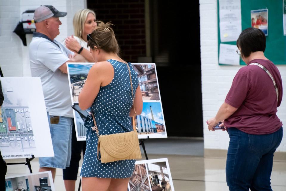 Attendees at the informational meeting concerning the sale of New Concord Elementary looks over project renderings from Connect Realty.