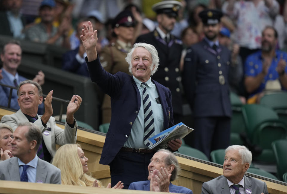 FILE - Rugby legend JPR Williams waves as he stands in the Royal Box after being introduced on Centre Court on day six of the Wimbledon tennis championships in London, on July 8, 2023. JPR Williams, the Wales rugby great of the 1970s known for his fearlessness and swashbuckling attacking style, has died. He was 74. His death was announced Monday Jan. 8, 2024 by Bridgend Ravens, a club that Williams served as a player and club president. (AP Photo/Alastair Grant, File)