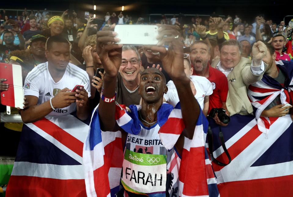 <p>Mohamed Farah of Great Britain takes a photo after winning gold in the Men’s 5000 meter Final on Day 15 of the Rio 2016 Olympic Games at the Olympic Stadium on August 20, 2016 in Rio de Janeiro, Brazil. (Photo by Patrick Smith/Getty Images) </p>