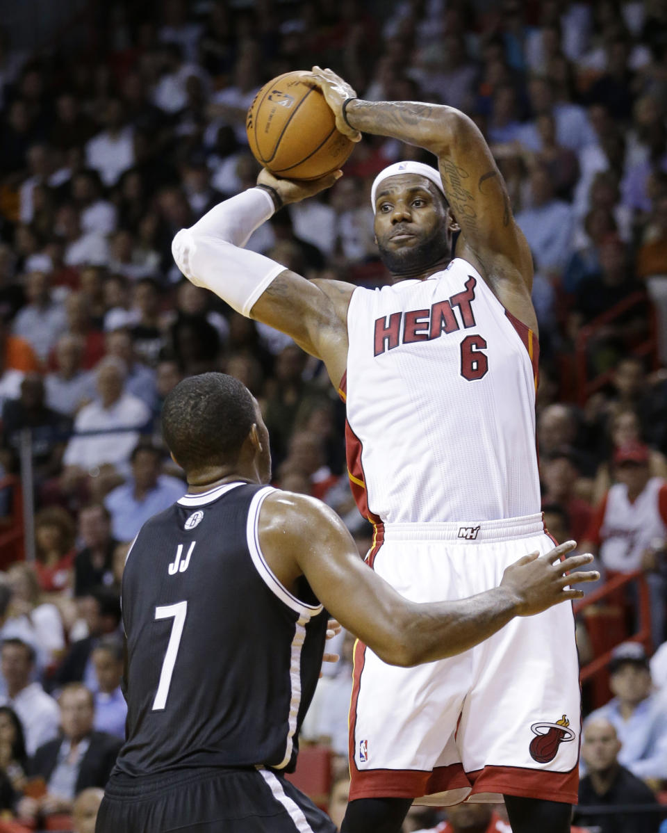 Miami Heat forward LeBron James (6) passes past Brooklyn Nets guard Joe Johnson (7) during the first half of an NBA basketball game, Tuesday, April 8, 2014 in Miami. (AP Photo/Wilfredo Lee)