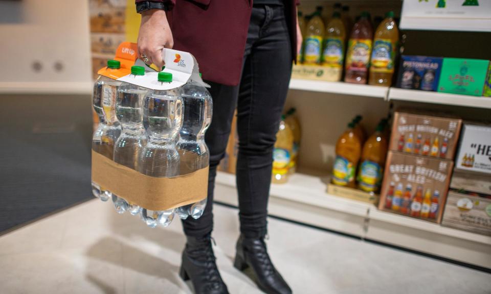 <span>Retailers are flocking to see DS Smith’s ideas for replacing plastic, such as a card-top lift-up bottle carrier with paper wrap, shown in its mock drink’s aisle. </span><span>Photograph: Joshua Bright/The Guardian</span>