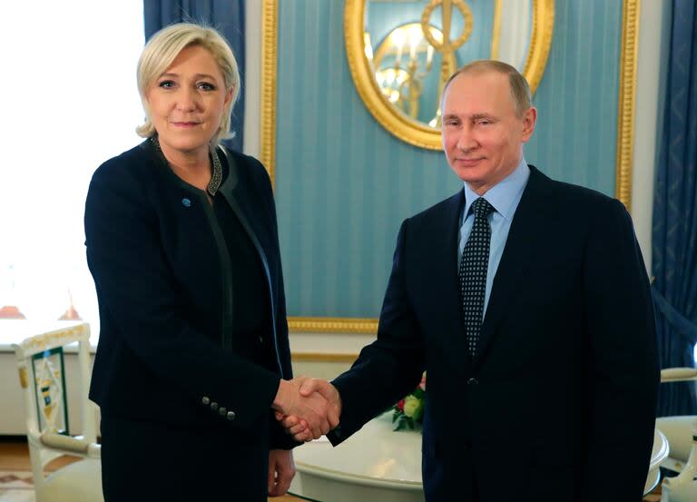 En marzo de 2017, el presidente ruso Vladimir Putin estrecha la mano de la entonces candidata presidencial francesa, Marine Le Pen (Mikhail Klimentyev, Sputnik, Kremlin Pool Photo via AP, File)