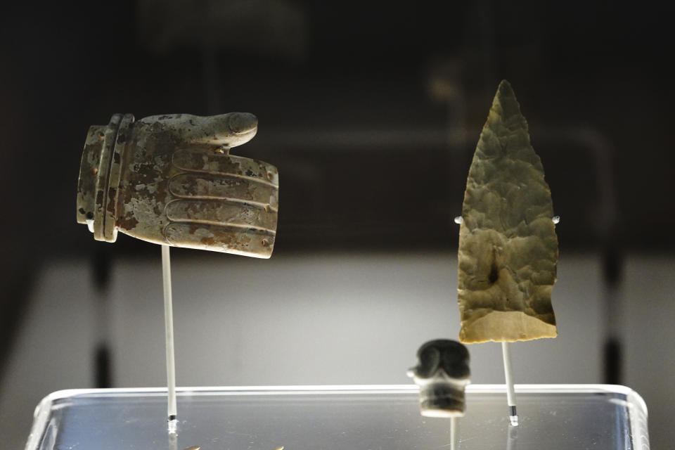 A hand carved stone and arrowhead are shown as part of the exhibition "The Greatness of Mexico" displaying for the first time in the country more than 800 pieces repatriated from abroad in the last three years and others that were in safekeeping and confiscation warehouses, at the Anthropology Museum in Mexico City, Friday, Oct. 1, 2021. (AP Photo/Marco Ugarte)