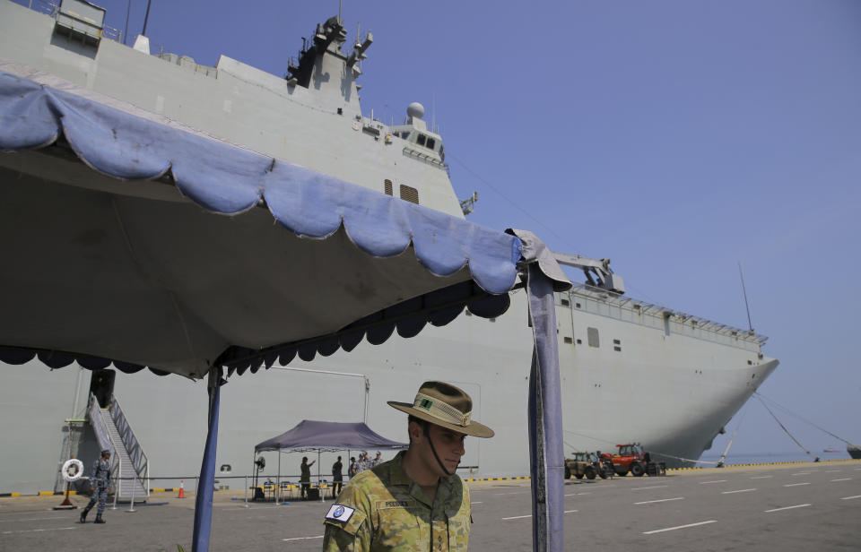 FILE - In this March 29, 2019, file photo, an Australian army officer stands next to the HMAS Canberra, one of four Royal Australian Navy ships visiting Sri Lanka as part of defense corporation between the two countries, in Colombo, Sri Lanka. Scholar Euan Graham, who was onboard the Royal Australian Navy flagship HMAS Canberra on a voyage from Vietnam to Singapore earlier in May, said that the lasers had been pointed from passing fishing vessels while the Canberra was being trailed by a Chinese warship. (AP Photo/Eranga Jayawardena, File)
