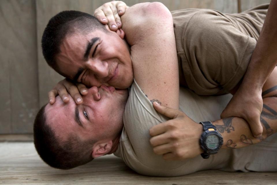 Bobby kisses Cortez udring a play fight at the barracks of Second Platoon at the Korengal Outpost. Korengal Valley, Kunar Province, Afghanistan. June 2008. (©Tim Hetherington)