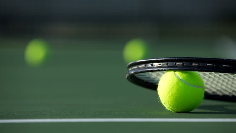 Tennis Ball and Racket with more balls off in the distance