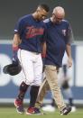 Minnesota Twins' Eddie Rosario, left, is helped off the field by trainer Tony Leo after he twisted his ankle while rounding first base on a hit during the third inning of the team's baseball game against the Tampa Bay Rays on Wednesday, June 26, 2019, in Minneapolis. (AP Photo/Jim Mone)