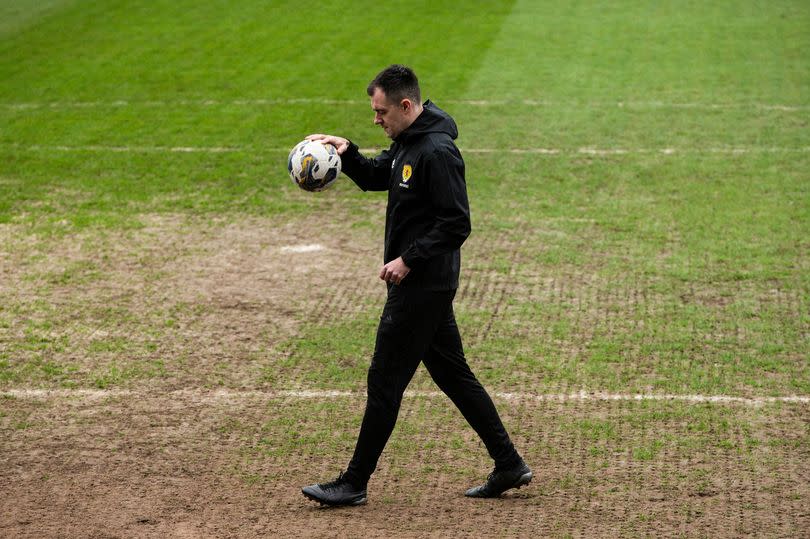 Ref Don Robertson carries out a Dens Park pitch inspection