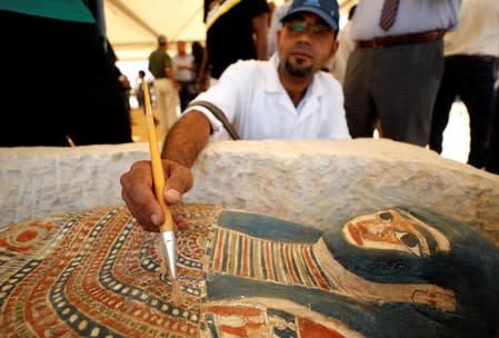 An archeological worker displays a sarcophagus that was discovered near the King Amenemhat II pyramid, south of Cairo