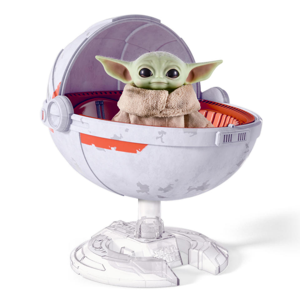 A plush doll of Baby Yoda, from Star Wars: The Mandalorian, inside a standing white pram