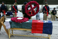 A police official lays a wreath over the coffin of a police officer, a victim of Monday's suicide bombing, during a funeral, in Peshawar, Pakistan, Feb. 2, 2023. A suicide bomber who killed 101 people at a mosque in northwest Pakistan this week had disguised himself in a police uniform and did not raise suspicion among guards, the provincial police chief said on Thursday. (AP Photo/Muhammad Sajjad)