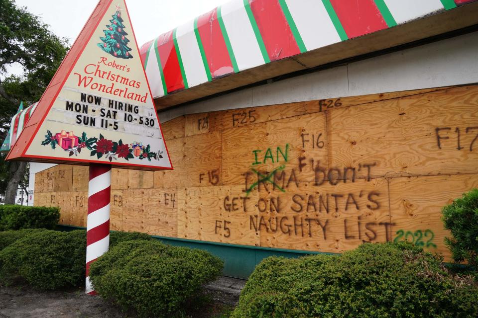 A Christmas themed store is boarded up with messages for Hurricane Ian on September 27, 2022 in Clearwater, Florida.