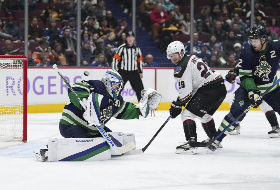 Vancouver Canucks goalie Spencer Martin, left, allows a goal to Arizona Coyotes' Jakob Chychrun, not seen, as Coyotes' Barrett Hayton (29) and Canucks' Luke Schenn (2) watch during the second period of an NHL hockey game Saturday, Dec. 3, 2022, in Vancouver, British Columbia. (Darryl Dyck/The Canadian Press via AP)