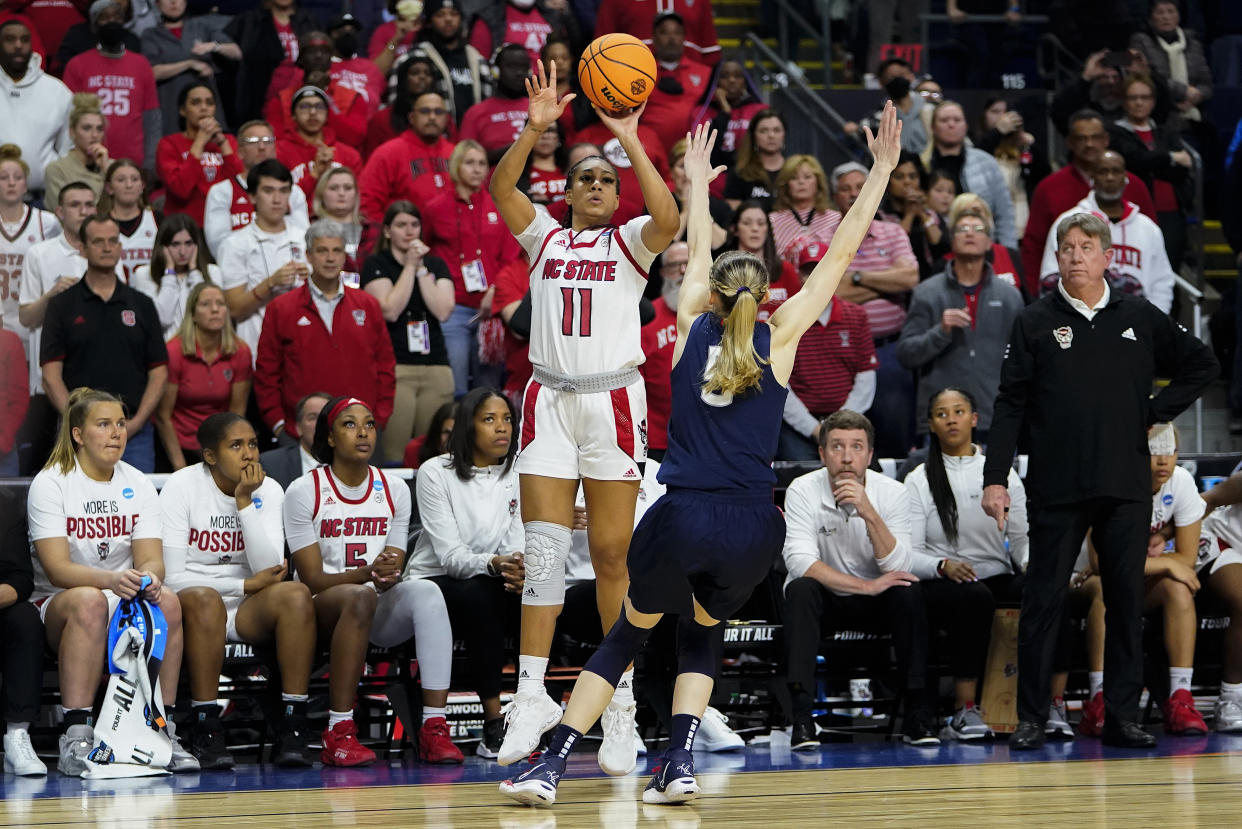 NC State forward Jakia Brown-Turner (11) puts up a three point shot against nConnecticut guard Paige Bueckers (5) to tie the game at the end of overtime in the East Regional final college basketball game of the NCAA women's tournament, Monday, March 28, 2022, in Bridgeport, Conn. (AP Photo/Frank Franklin II)