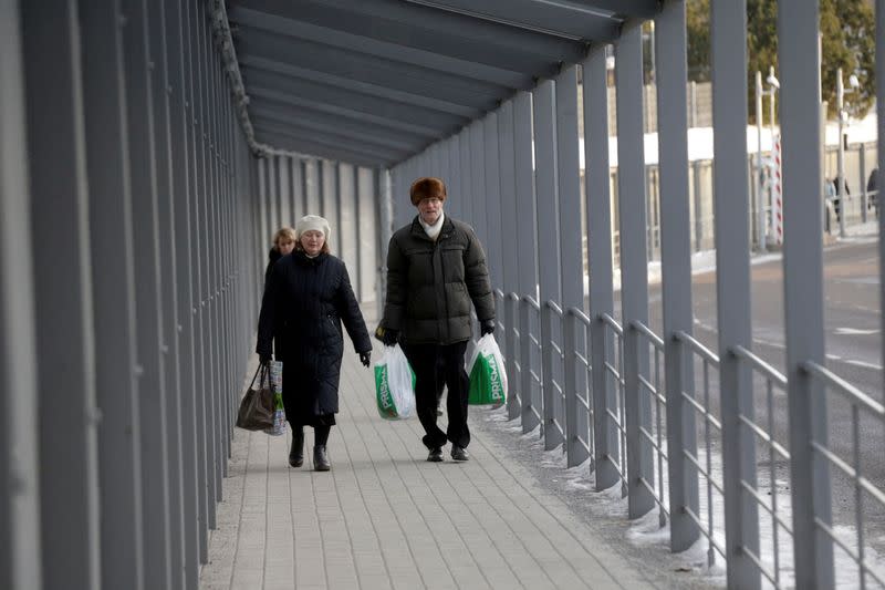 FILE PHOTO: People walk on bridge over Narva river at the border crossing point with Russia in Narva