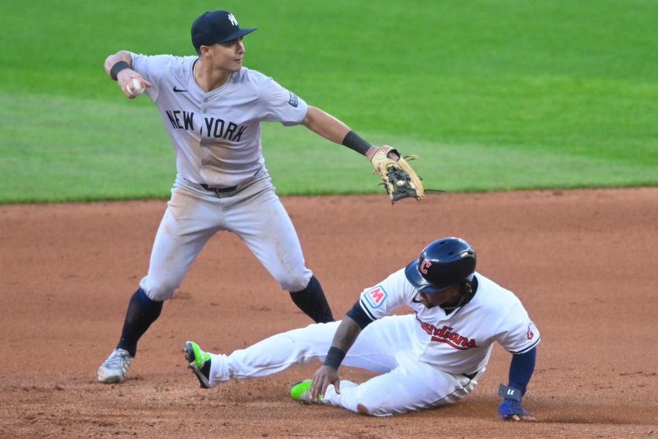 New York Yankees shortstop Anthony Volpe (11) turns a double play beside Cleveland Guardians baserunner Jose Ramirez (11) in the fourth inning Saturday in Cleveland.