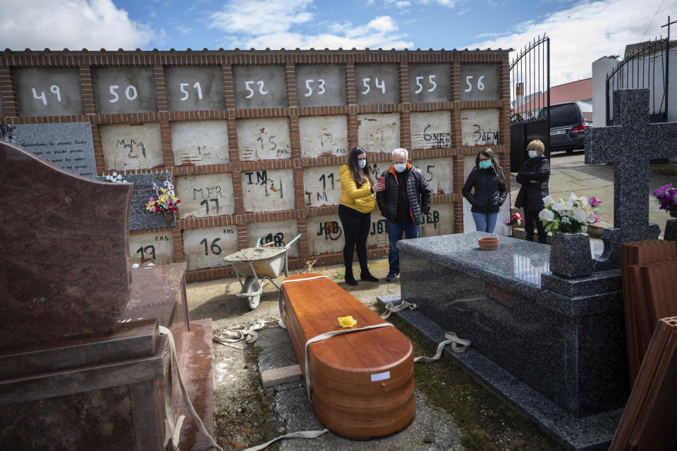 Family members attend the burial of Rosalia Mascaraque, 86, during the coronavirus outbreak in Zarza de Tajo, central Spain, Wednesday, April 1, 2020. Intensive care units are particularly crucial in a pandemic in which tens of thousands of patients descend into acute respiratory distress. The new coronavirus causes mild or moderate symptoms for most people, but for some, especially older adults and people with existing health problems, it can cause more severe illness or death. (AP Photo/Bernat Armangue)