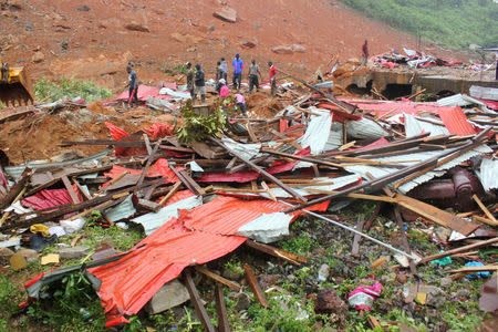 People inspect the damage after a mudslide in the mountain town of Regent, Sierra Leone August 14, 2017. REUTERS/Ernest Henry