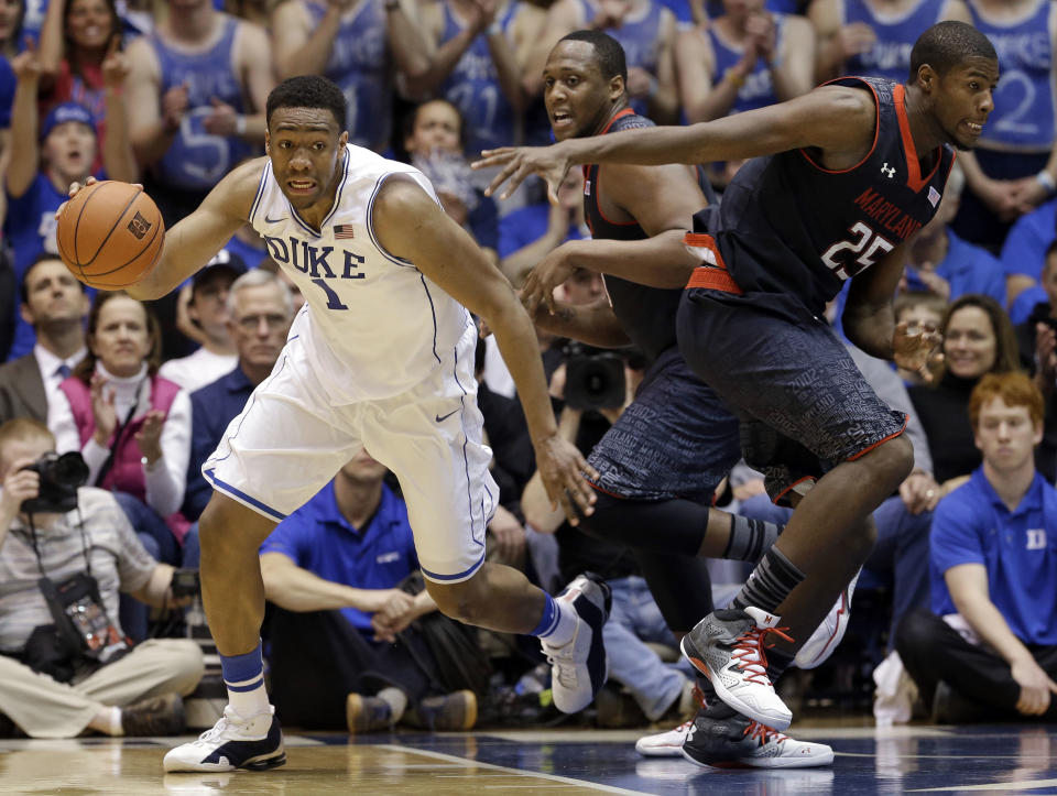 Duke's Jabari Parker (1) dribbles the ball as Maryland's Jonathan Graham (25) and Charles Mitchell, rear, defend during the first half of an NCAA college basketball game in Durham, N.C., Saturday, Feb. 15, 2014. (AP Photo/Gerry Broome)