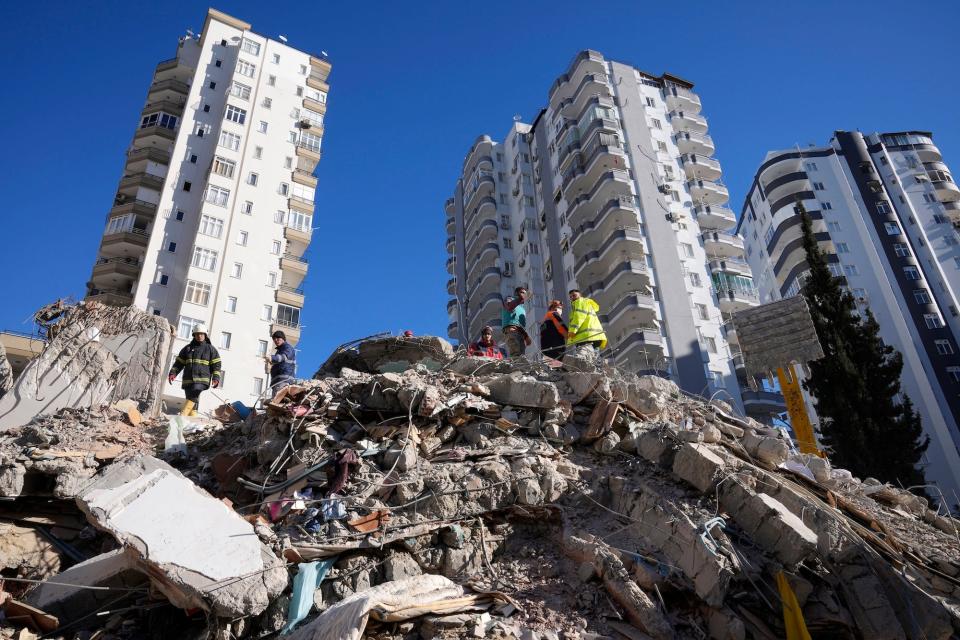 Emergency teams search for people in the rubble of a destroyed building in Adana, southern Turkey, Tuesday, Feb. 7, 2023.