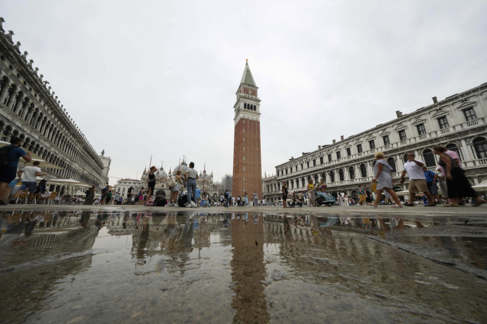 Tourists walk around St Mark's square in Venice, Italy, Wednesday, Sept. 13, 2023. The Italian city of Venice has been struggling to manage an onslaught of tourists in the budget travel era. The stakes for the fragile lagoon city are high this week as a UNESCO committee decides whether to insert Venice on its list of endangered sites. (AP Photo/Luca Bruno)
