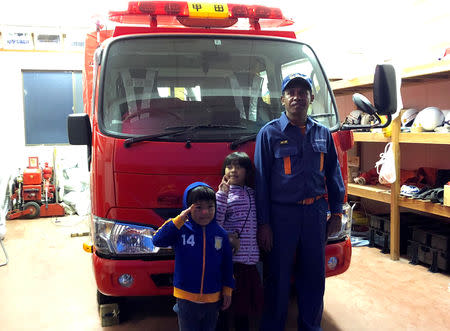 East Timorese Leonel Maia, 33, poses for a photograph with his children at a fire station where he volunteers as a firefighter in Akitakata, Hiroshima prefecture, western Japan November 26, 2018. REUTERS/Ami Miyazaki/Files