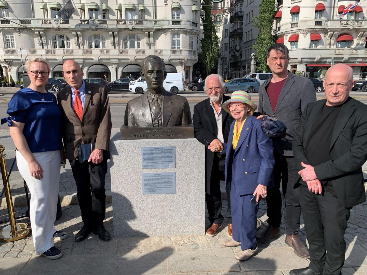Naples businessman Abe Asli, 78, with right elbow leaning on statue, and other dignitaries in Stockholm in late May. Asli honored Raoul Wallenberg, a Swedish diplomat who helped to rescue Jews during the Holocaust of World War II.