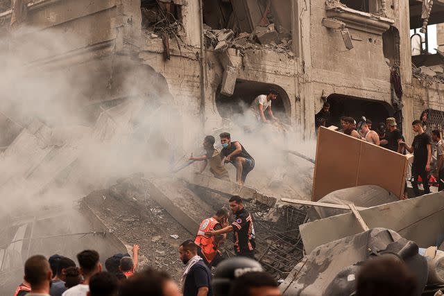 <p>hoto by MAHMUD HAMS / AFP) (Photo by </p> Palestinians search for survivors after an Israeli airstrike on the refugee camp of Jabalia in the Gaza Strip