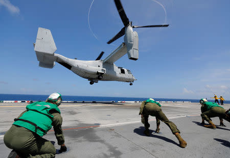 Flight deck crew aboard the USS Kearsarge aircraft carrier brace themselves from the propeller wash of a departing MV-22B Osprey in the service of the Marine Corps as U.S. military continues to evacuate from the U.S. Virgin Islands in advance of Hurricane Maria, in the Caribbean Sea near the islands September 17, 2017. Picture taken on September 17, 2017. REUTERS/Jonathan Drake