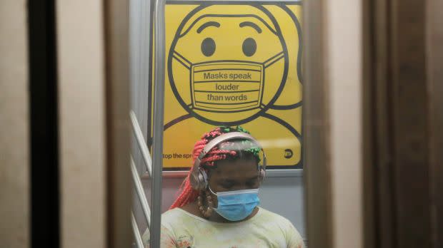 A commuter wears a mask under public safety signage as cases of the infectious coronavirus Delta variant continue to rise in New York City, New York