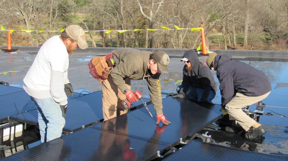 Employees of HOMES Inc. install solar panels on the roof of the Middlesboro Community Center on Dec. 7, 2023, which will cut the energy bill at the center. From left,the employees are Derrick Potter, Reuben Long, Keylan Vanover and Kelly Sexton.