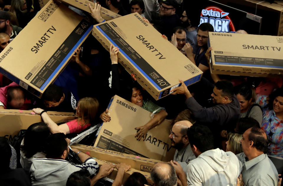 Shoppers reach out for television sets as they compete to purchase retail items on Black Friday at a store in Sao Paulo, Brazil, November 23, 2017.  REUTERS/Paulo Whitaker     TPX IMAGES OF THE DAY