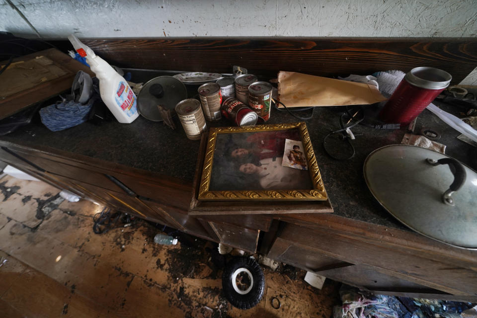 A photo of a younger Vorina Roussell, who is now bed-bound from a stroke and living in a trailer with Irene Verdin, sits inside Irene's home that was heavily damaged by Hurricane Ida nine months before, along Bayou Pointe-au-Chien, La., Tuesday, May 24, 2022. (AP Photo/Gerald Herbert)