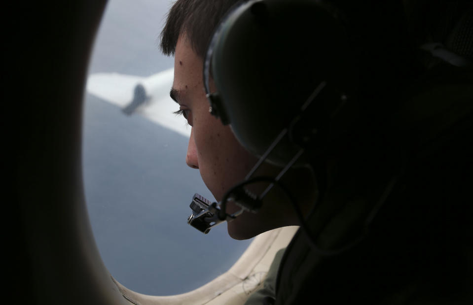 FILE - In this March 22, 2014 file photo, Sgt. Matthew Falanga on board a Royal Australian Air Force AP-3C Orion, search for the missing Malaysia Airlines flight MH370 in southern Indian Ocean, Australia. Not one object has been recovered from the missing airliner that Malaysian officials are now convinced plunged into the southern Indian Ocean 17 days ago. Some of the pieces are likely 3,500 meters (11,500 feet) underwater. Others are bobbing in a fickle system of currents that one oceanographer compares to a pinball machine. And by now, they could easily be hundreds of kilometers (miles) away from each other. (AP Photo/Rob Griffith, File)