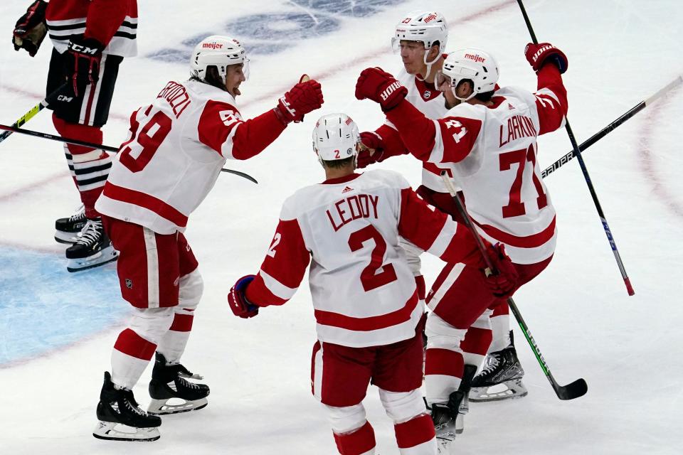 Detroit Red Wings left wing Tyler Bertuzzi, left, celebrates with teammates after scoring a goal against the Chicago Blackhawks during the second period of an NHL hockey game in Chicago, Sunday, Oct. 24, 2021.