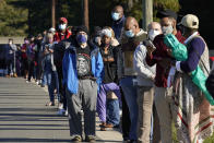 Early voters wait to cast their ballots at the South Regional Library polling location in Durham, N.C., Thursday, Oct. 15, 2020. (AP Photo/Gerry Broome)