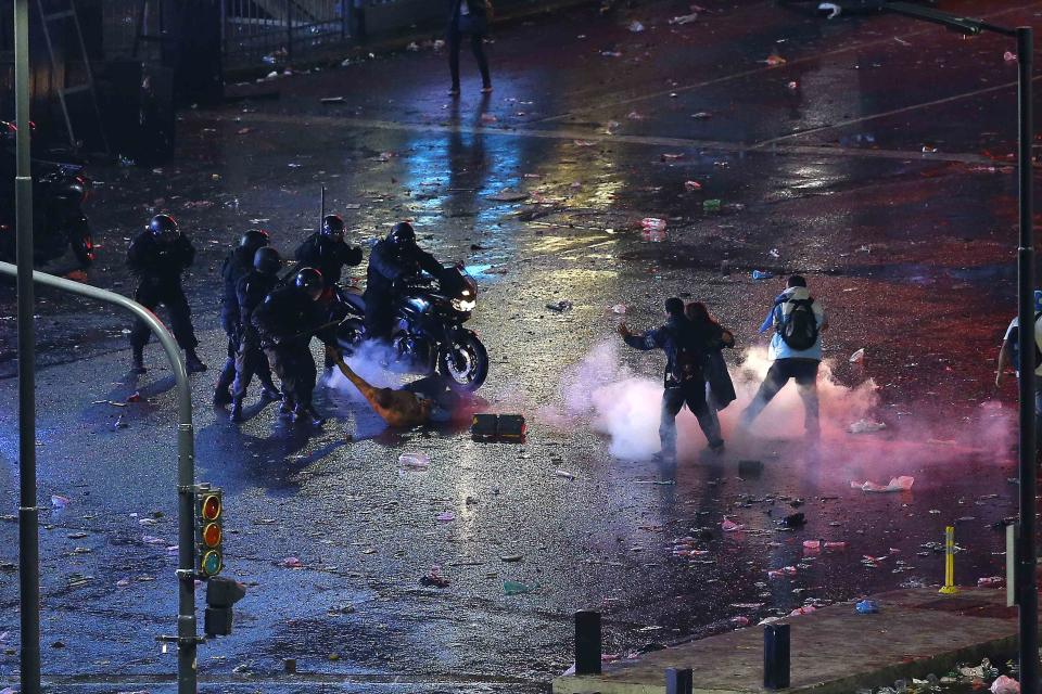 An Argentine fan is detained during clashes with riot police in Buenos Aires after Argentina lost to Germany in their 2014 World Cup final soccer match in Brazil, July 13, 2014. (REUTERS/Ivan Alvarado)